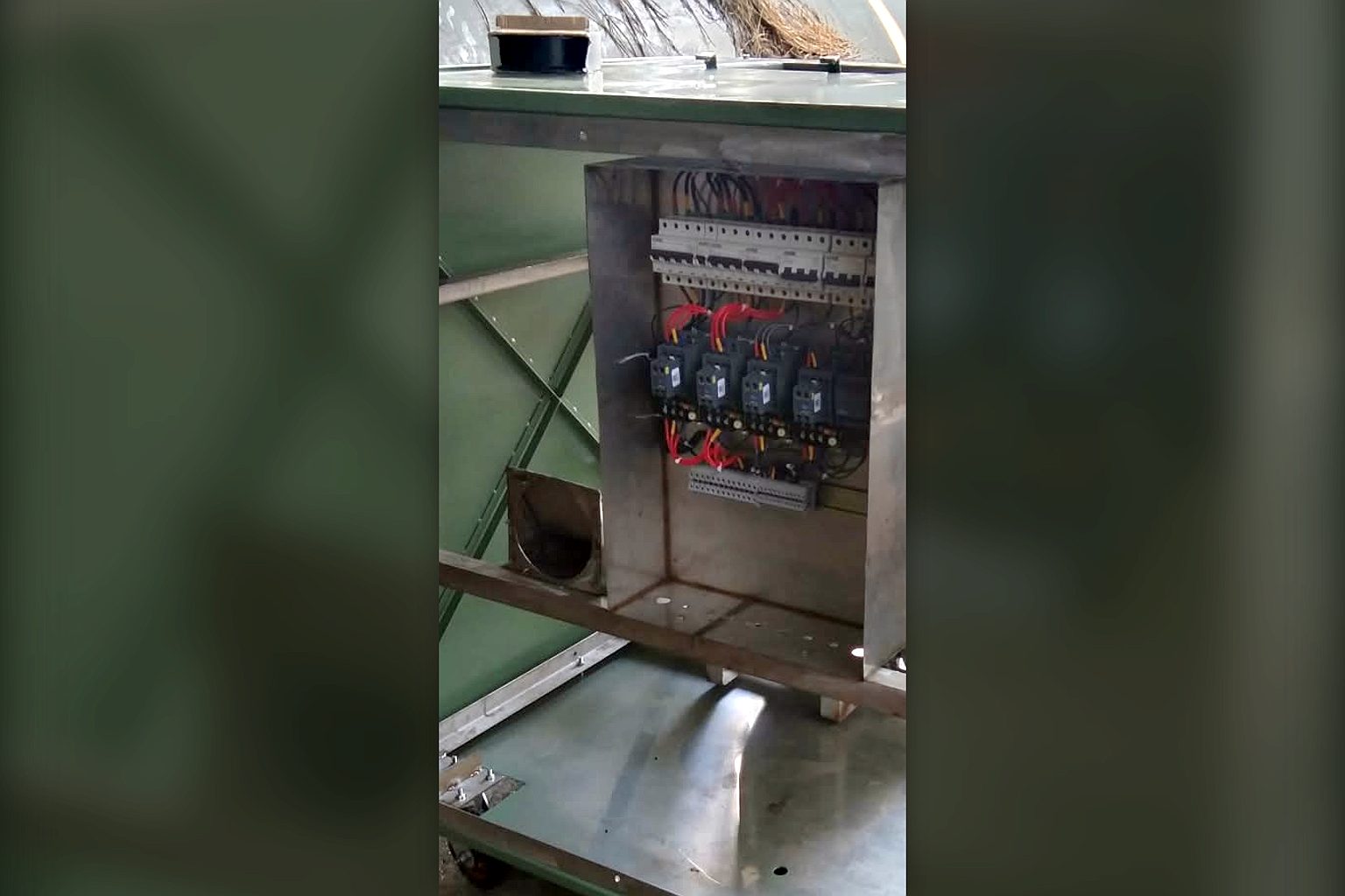 Stainless steel composter frame with the electrical control panel open, showing MCBs, contactors and wiring during fabrication at the TGMC workshop