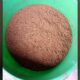Dark brown granular output from a TGMC composter collected in a green tub