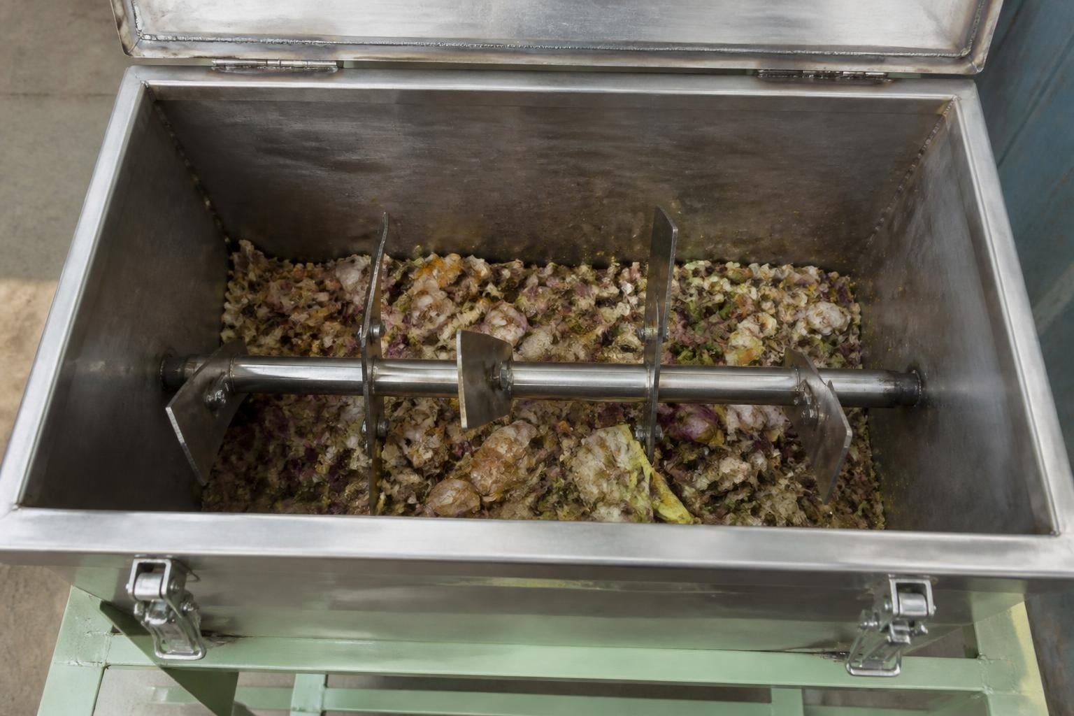 Inside the open SS 304 composting tank of an organic waste converter, with a paddle agitator turning shredded food waste