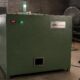 TGMC organic waste composter in a green cabinet with tower light, temperature displays and the GMC nameplate, on the workshop floor before trial