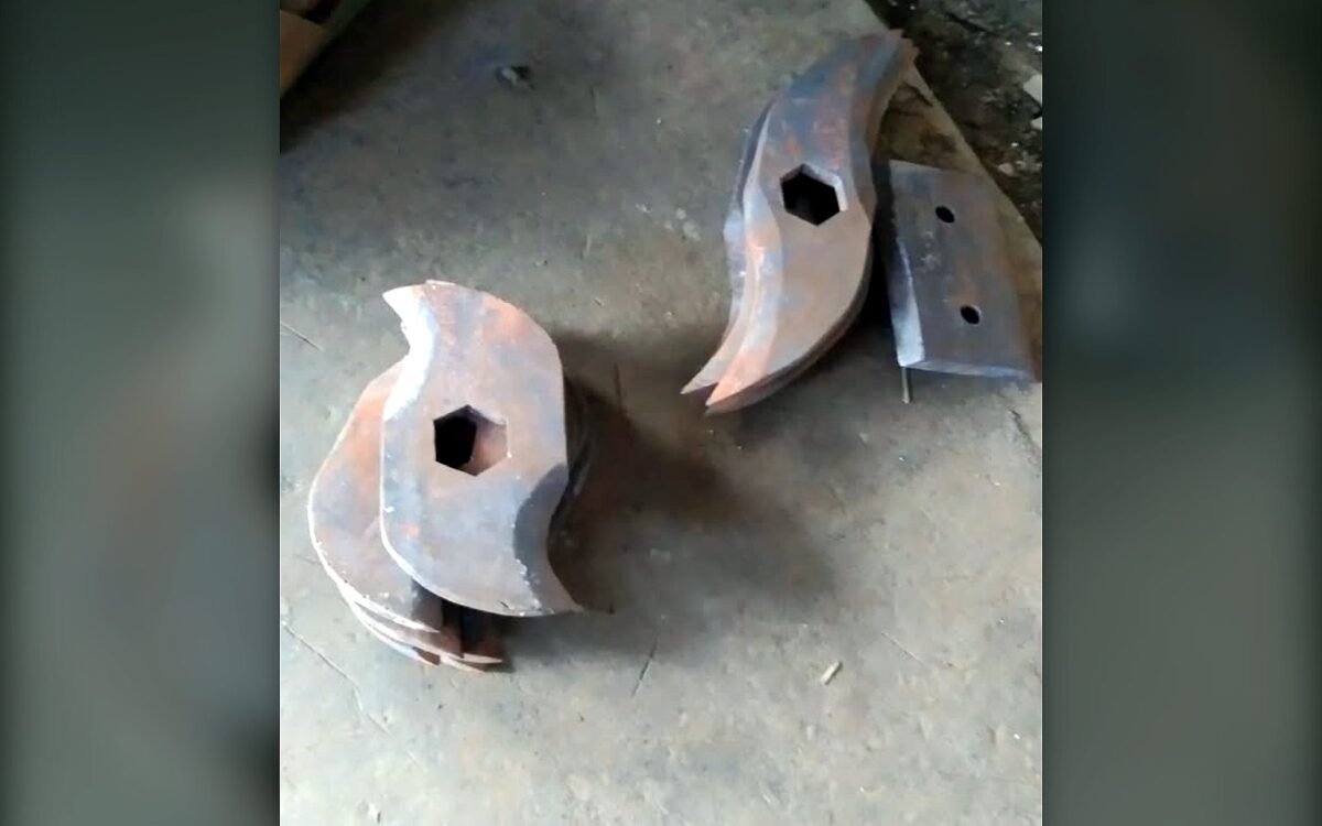 Two hooked steel shredder cutter discs with hexagonal bores on the workshop floor before fitting to a TGMC composter shredder shaft